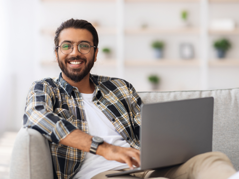 smiling man using a laptop McKnight & McKnight Insurance Solutions