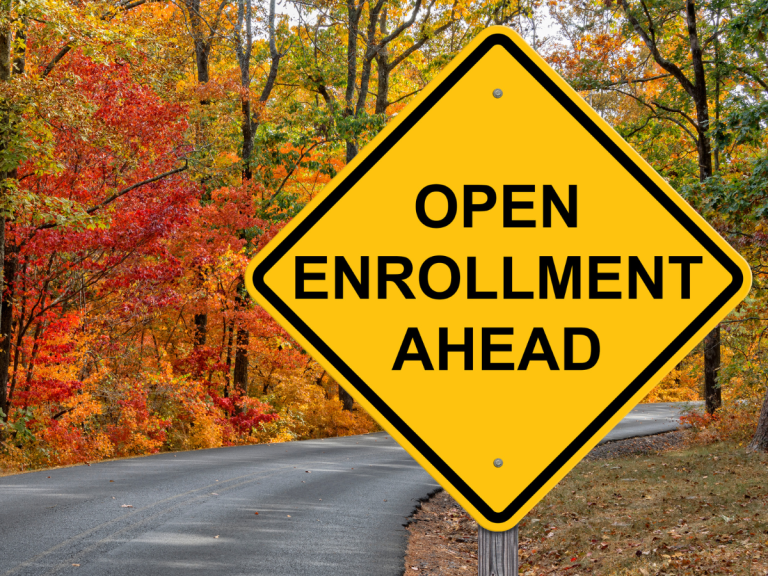 open enrollment sign near fall leaves